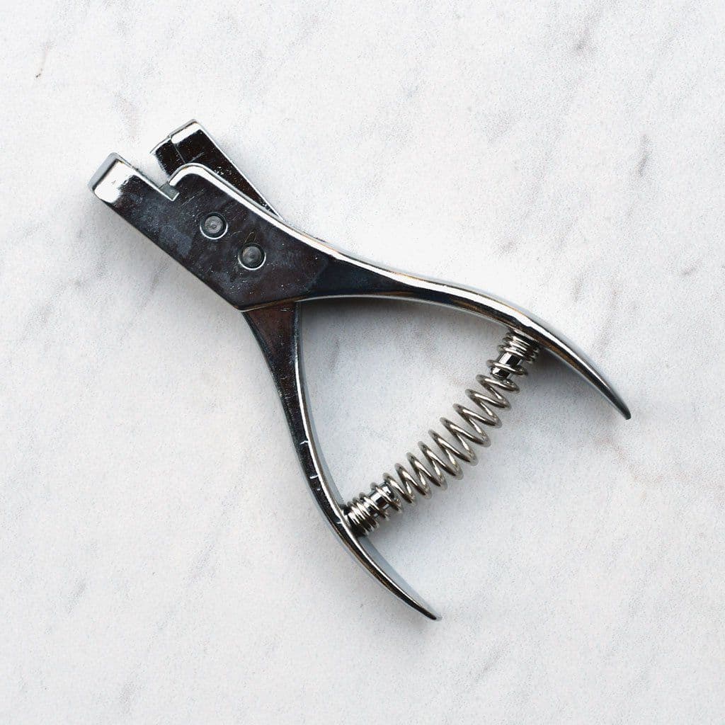 Notcher tool creating small marks on fabric edge, close-up view — ONSA sewing blog